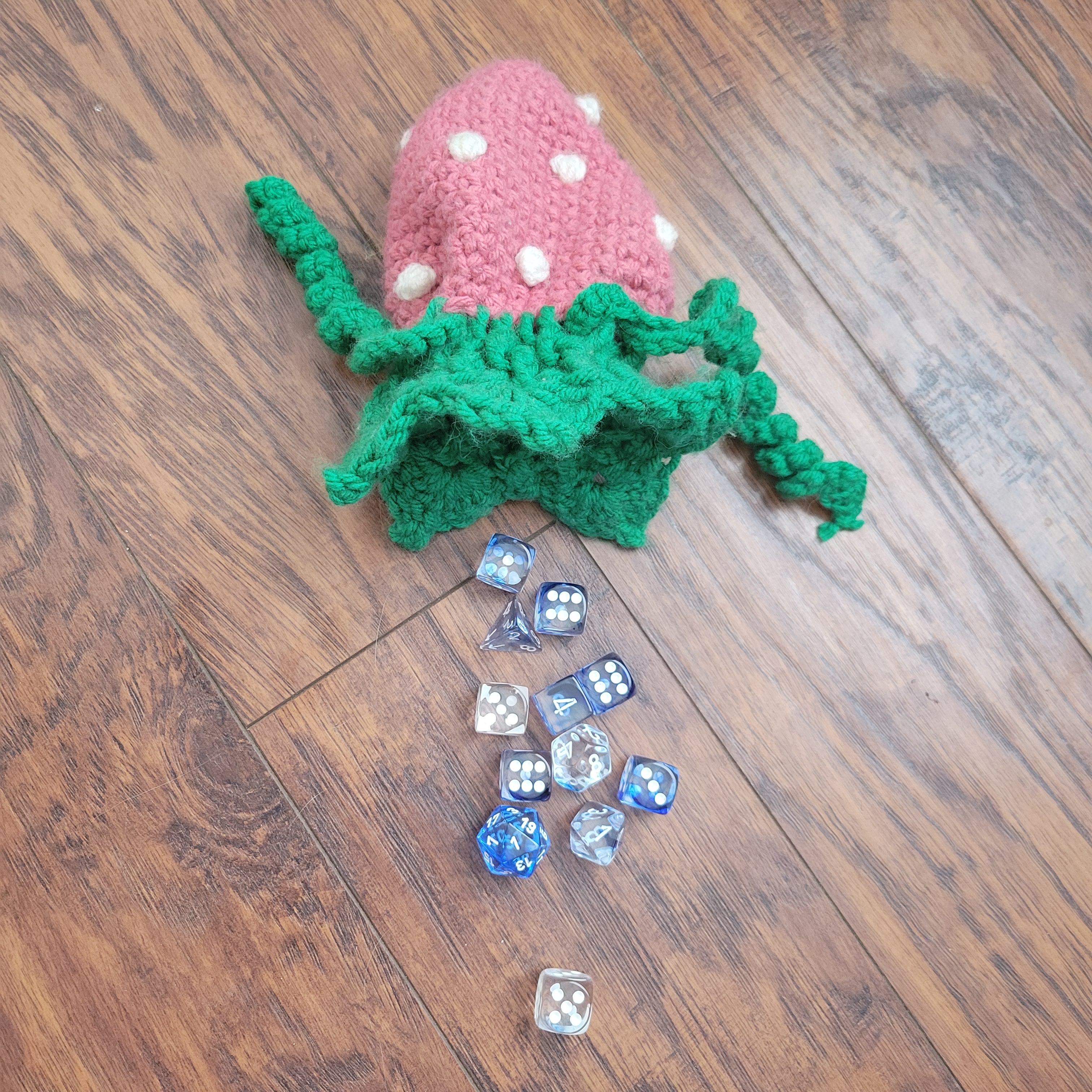 crochet strawberry dice bag spilling blue and clear dice